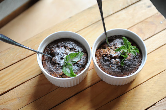 Dessert healthy breakfast of oat pudding in a white keraimic mold. Decorated with a sprig of mint and powdered sugar.