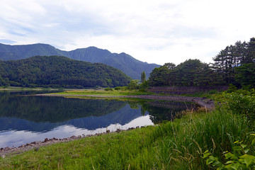 Peaceful nature scene with green mountains, trees and lake in Kawaguchiko near Mount Fuji, Japan