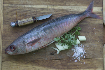 Fish on a kitchen board with vegetables