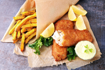 traditional British fish and chips on brown paper - obrazy, fototapety, plakaty