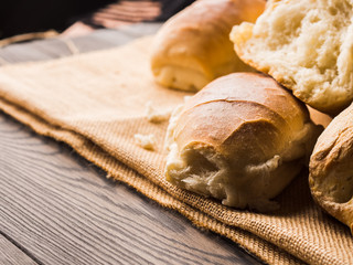Freshly baked bread loaves on burlap dark wooden background. Texture closeup italian bakery products