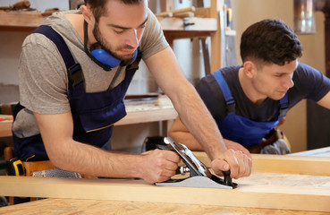 Young carpenters working in shop