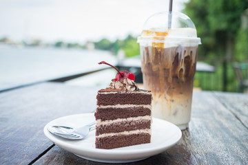 chocolate cake with cherry topping and ice coffee mocha in outdoor cafe