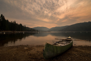 Fototapeta na wymiar Canoe and paddle on shore of Pinecrest Lake in California 