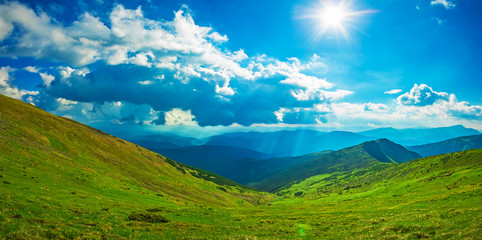 Fototapeta na wymiar Panoramic view of the sky and mountain ridges from the top of the mountain in a sunny summer day