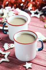 Christmas cookies with cup of hot coffee on a red wooden table