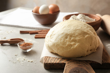Raw dough with ingredients for cinnamon roll on kitchen table