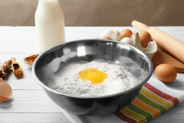 Bowl with flour and egg on kitchen table