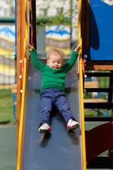 One year old baby boy toddler wearing green sweater at playground