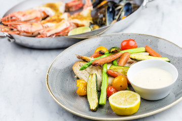 Grilled fish and vegetables with sauce with royal prowns and mussle