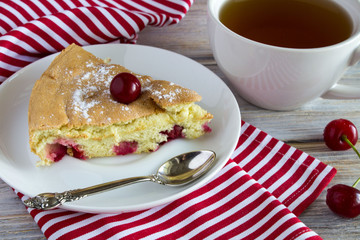 Biscuit with cherry and tea on the wooden background
