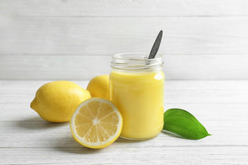 Beautiful composition with delicious lemon curd on wooden background