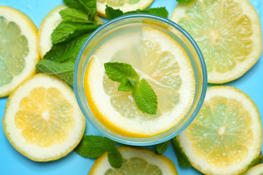 Glass of delicious lemonade on color background