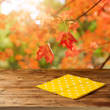 Empty Wooden Table With Tablecloth Over Fall Leaves Background. Autumn Season Concept