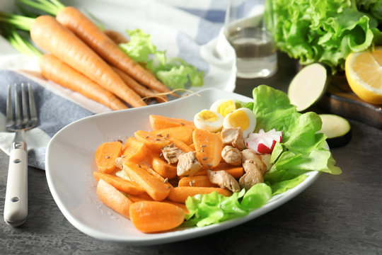 Delicious carrot salad in plate on kitchen table