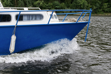 Fototapeta premium The bow of a blue ship breaking water