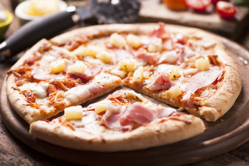 Pizza with a topping of Ham and Pineapple