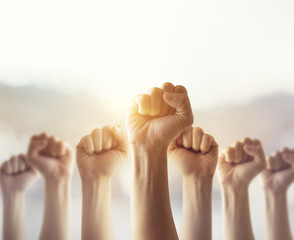 People raised fist air fighting for their rights with sunlight effect,  labor movement, election...