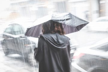 girl with umbrella on street in rain ,  blur