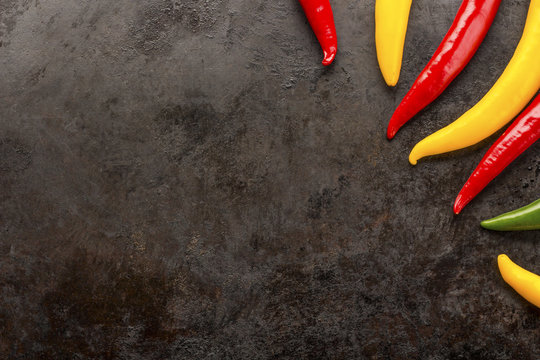 cayenne chilli peppers on rusty metal background