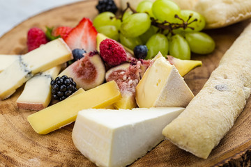 Cheese plate with bread grapes and strawberries