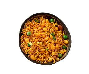Traditional Indian snack namkeeni in coconut shell cup. A mixture of roasted nuts, puffed rice, dried fruits and roasted grams, seasoned with various spices. Copy space. Isolate