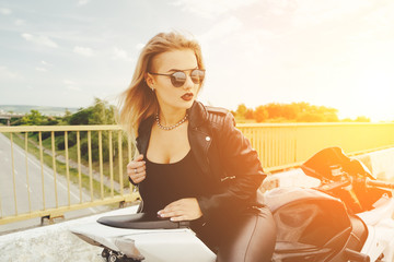 Fototapeta premium Biker girl in a leather clothes on a motorcycle