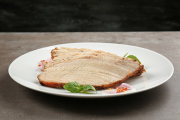 Plate with delicious sliced turkey on table