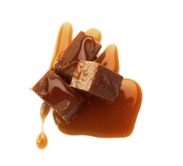 Tasty caramel sauce with candies on white background