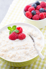 Oatmeal porridge in bowl with berries raspberries and blackberries.