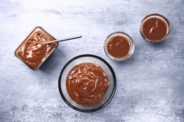 Glass bowls with tasty caramel sauce on table