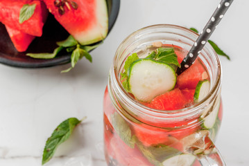 Summer drinks and cocktails. Lemonade, infused detox water with mints, fresh watermelon and cucumber. In mason jar, on a white marble table. Copy space close view