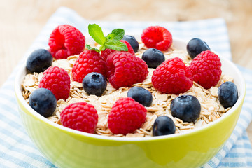 Oatmeal porridge with berries. Raspberries and blueberries.