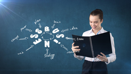 Woman in a suit holding report near wall with a business idea sketch drawn on it. Concept of a successful business.