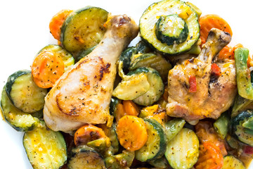 Fried chicken with vegetables in a frying pan. Chicken legs with barbecue and vegetables close-up background.