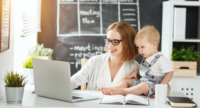 Businesswoman mother  woman with toddler working at computer