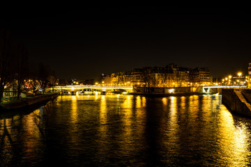Fototapeta na wymiar Night urban scene of a calm river crossing a big city