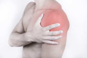 Close up view of a young man holding his shoulder in pain, isolated on white background. Shoulder and chest pain. Young man touching his shoulder for the pain. Red inflammation effect.