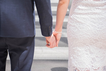 The newlyweds go hand in hand on the pedestrian crossing.