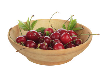 cherry with leaves in wooden plate isolated
