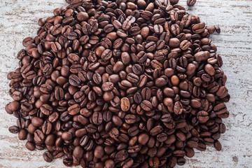 Roasted coffee beans on textured wood table