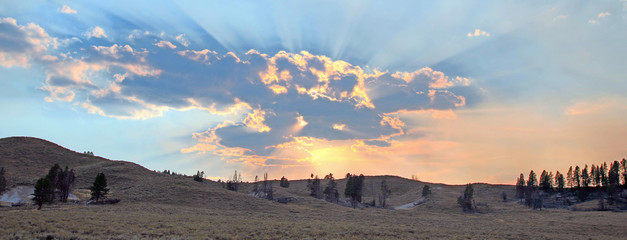 Sunbeams and sunrays through sunset clouds in the Hayden Valley in Yellowstone National Park in...