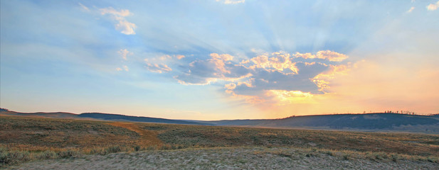 Sunbeams and sunrays through sunset clouds in the Hayden Valley in Yellowstone National Park in Wyoming USA