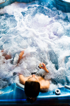 Girl drinking champagne in jacuzzi