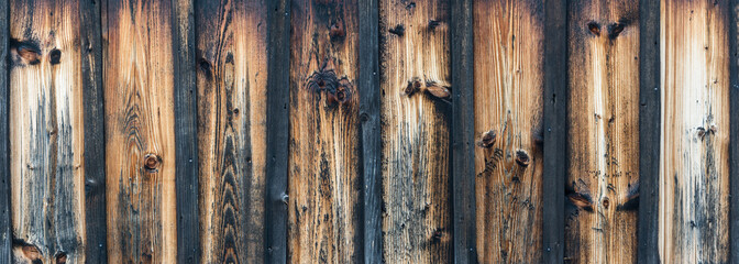 Blank striped wooden panoramic texture for background. Vintage faded wall with knots.