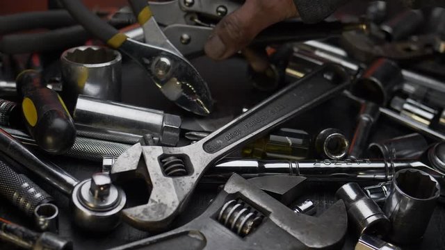 GREASY HAND GRABS A WRENCH.  SLOW MOTION, CLOSE UP.