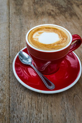 red coffee cup on wood board.