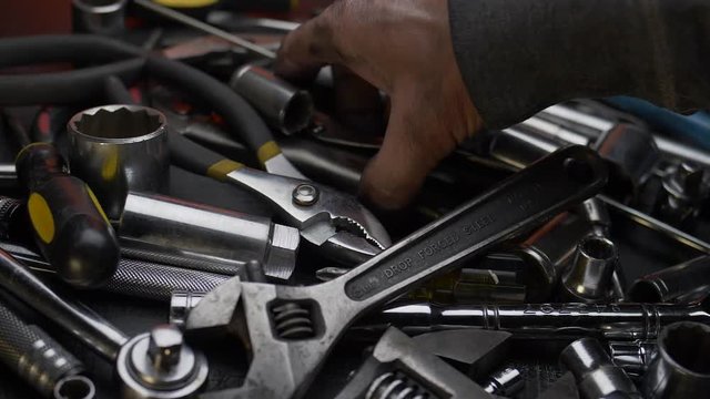 MAN'S HAND GRABS ATOOL.  SLOW MOTION, CLOSE UP, DOLLY SHOT.