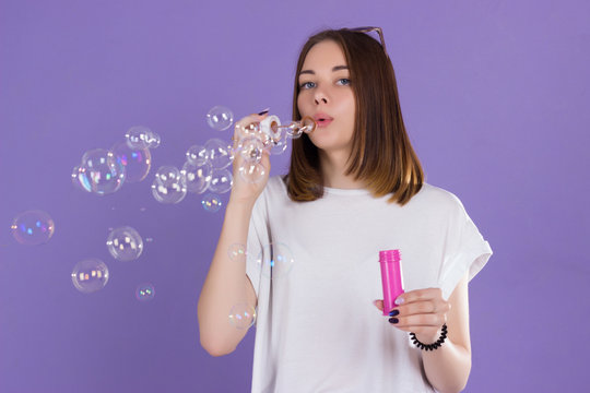 Young cute girl blows bubbles, pretty woman  