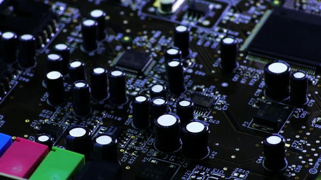 Rotating printed circuit board with microprocessors and capacitors, partially covered with electrostatic dust.